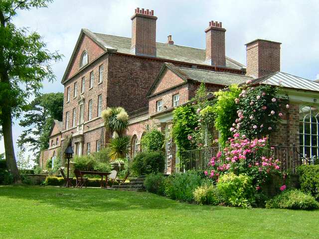 This shows the rear aspect of Sutton Park House leading onto the Top Terrace, with its reclaimed york stone paving and orangery at the side.